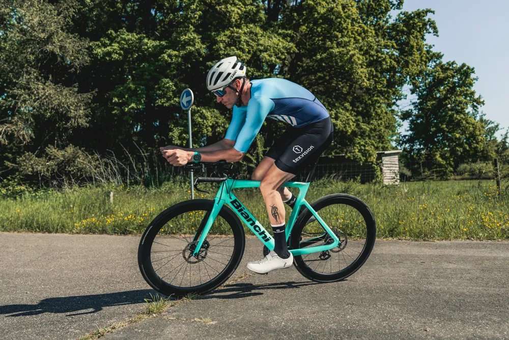 Wielrenner op een groene tijdritfiets buiten